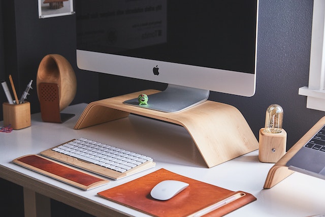 A white desk set up with a keyboard, mouse, and Mac desktop computer